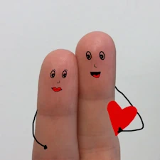 two fingers with hearts on them symbolizing a loving couple