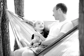 Father sitting with young son in hammock