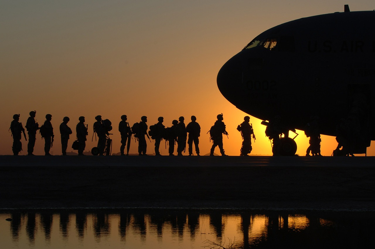 Soldiers in the distance preparing to board a troop carrier. This is at sunset.